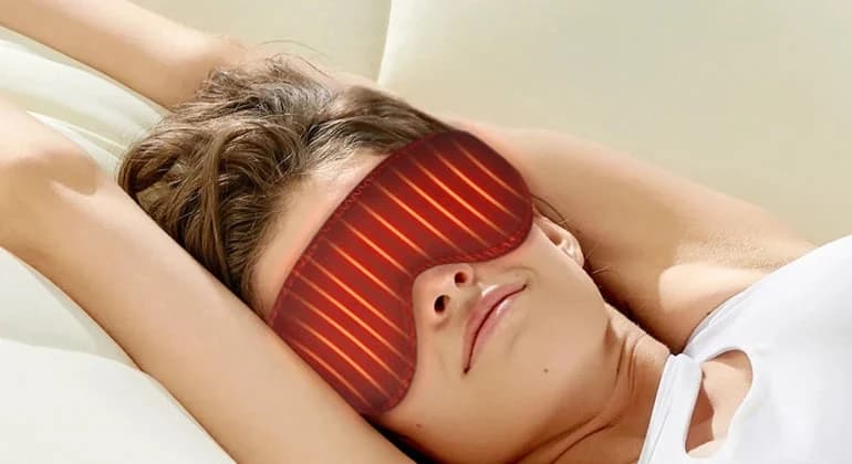 A woman asleep wearing the warm, glowing WarmEase mask